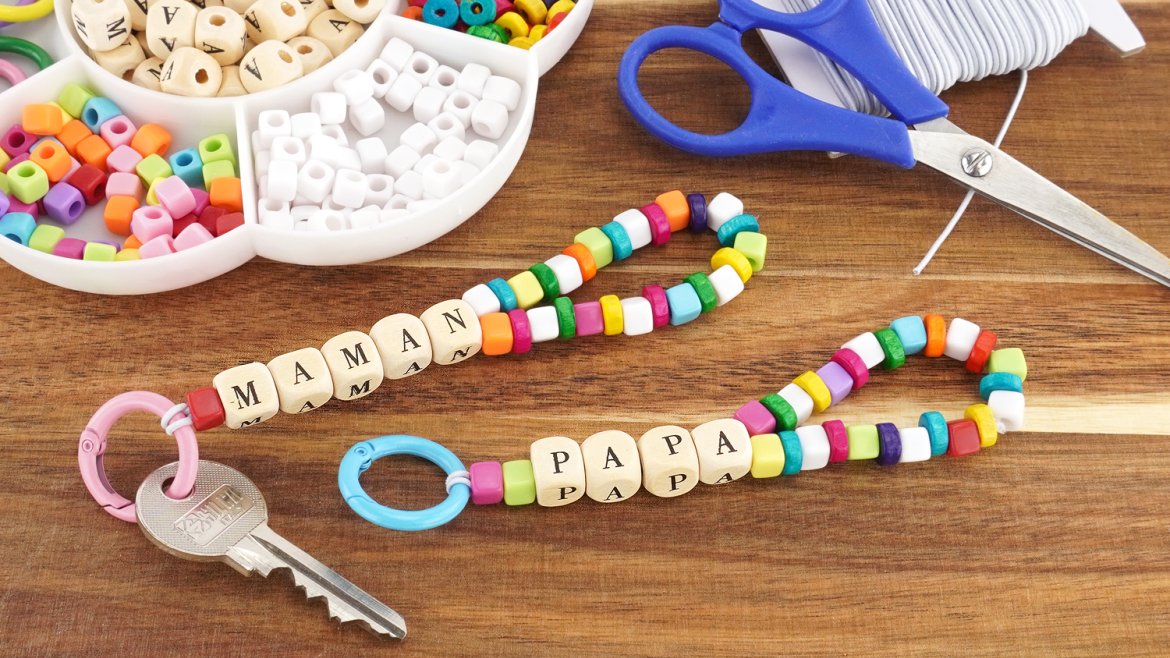 Créez un porte-clés personnalisé avec des perles et les mots PAPA ou MAMAN. Un bricolage affectueux dès 3 ans, à découvrir sur le site.