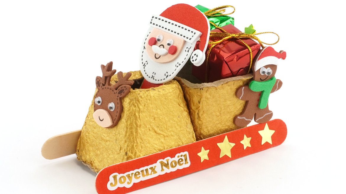 Retrouvez un tuto pour fabriquer un mignon petit traîneau de Père Noël avec des pots en carton et des bâtonnets.
