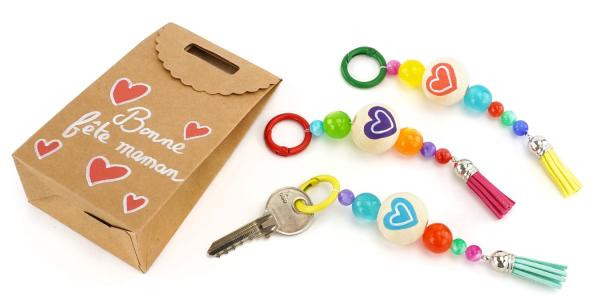 Fabriquez un joli porte-clés coloré à offrir pour la fête des mères avec des perles, pompons et feutres ! Une activité facile dès 3 ans.