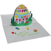 Préparation d'une jolie carte pop-up d'un ?uf de Pâque décoré de gommettes  placé dans l'herbe du jardin . Un bricolage papier en 3D pour la décoration de la maison.