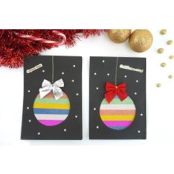 Découvrez comment réaliser une jolie carte de vœux boule de Noël ! Avec du masking tape, un nœud en tissu, des strass étoiles et des gommettes, nous allons réaliser une sublime carte de Noël que les e