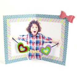 Découvrez comment réaliser une jolie carte pour la Fête des pères. En ouvrant la carte, papa aura la surprise de voir l'intérieur avec la photo de son petit loup ainsi que de jolies perles en bois. Un