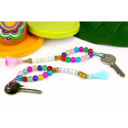 Avec des jolies perles, un peu de fil et quelques pompons nous allons fabriquer des portes-clés avec prénoms personnalisables. Un cadeau idéal à offrir pour la fête des mères !
