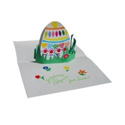 Préparation d'une jolie carte pop-up d'un ?uf de Pâque décoré de gommettes  placé dans l'herbe du jardin . Un bricolage papier en 3D pour la décoration de la maison.
