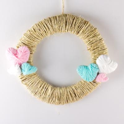 La couronne de la Saint Valentin de Tête à modeler est une jolie couronne en laine pleine de petits coeurs  en laine.