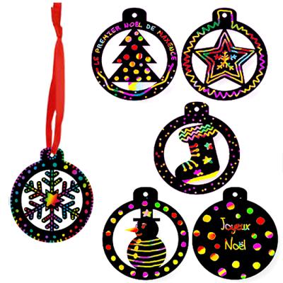 Et si le sapin de Noël était décoré de jolies boules multicolores en carte à gratter ? Les boules sont découpées dans de la carte à gratter noire, elles sont ajourées et il ne reste plus qu'à les déco